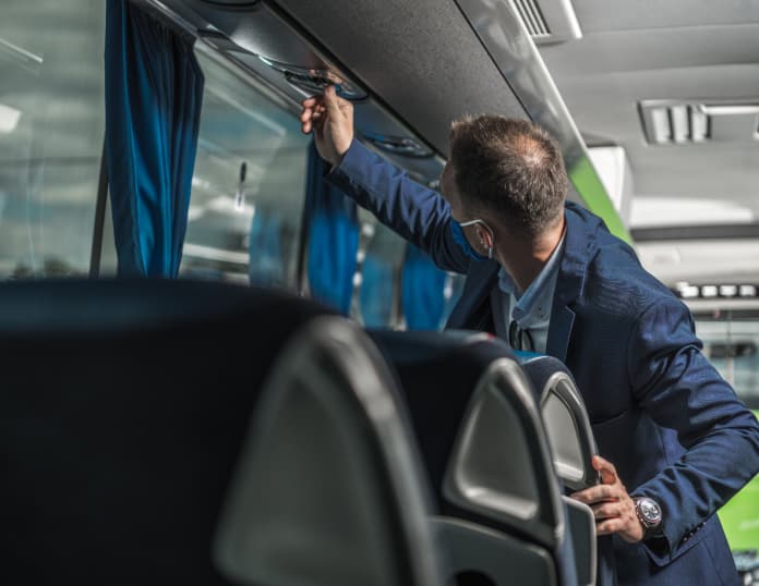 a driver adjusting a bus climate control